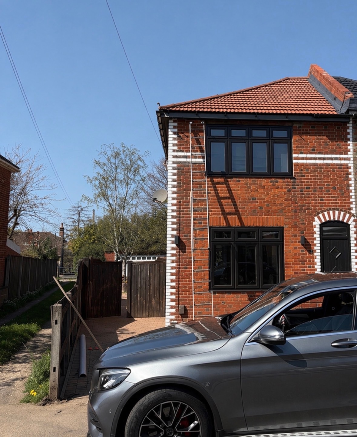 Dark grey UPVC sash windows on red brick property after spraying